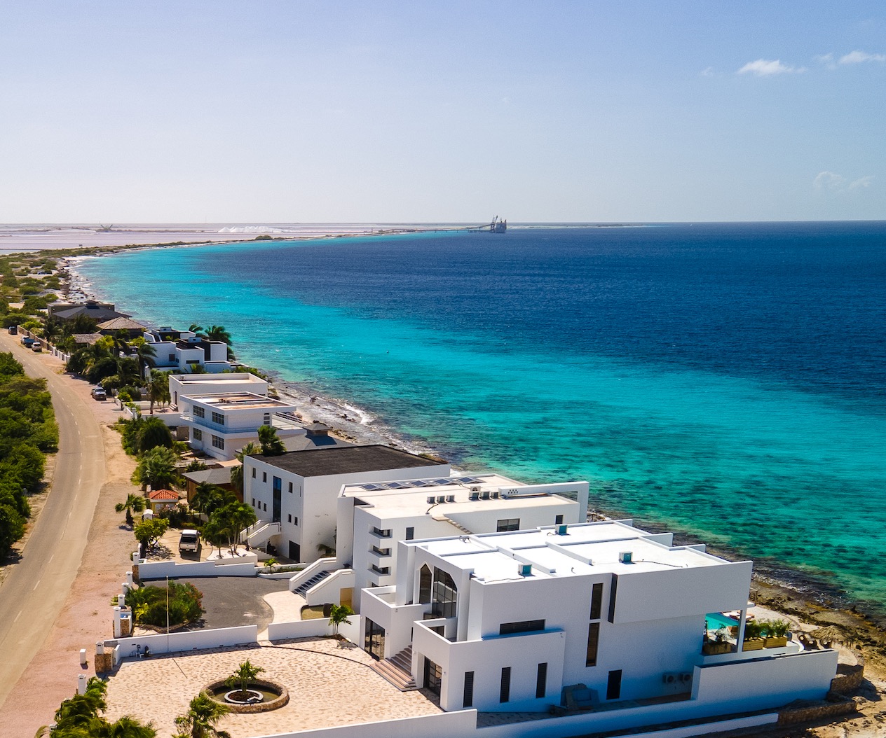 Aerial view of a luxury modern oceanfront villa in Bonaire with a private pool overlooking the turquoise Caribbean Sea.